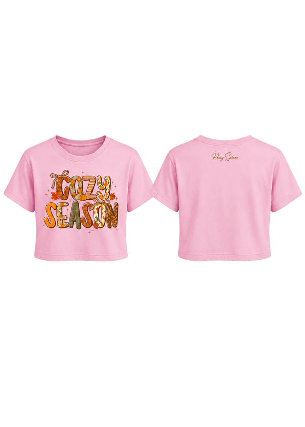 A pink short-sleeve crop top shown from both front and back. The front features a colorful graphic reading 'Kooky Season' in a warm autumn palette, and the back has a small gold script logo reading 'Peach Season'.
